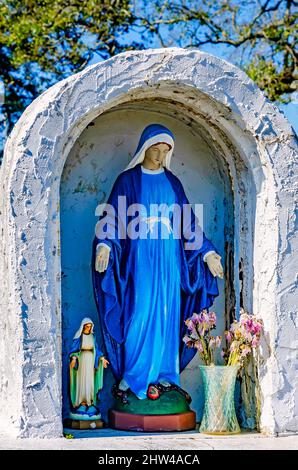 Una statua della Vergine Maria si trova accanto a un monumento alle vittime dell'aborto presso la chiesa cattolica di Santa Margherita a Bayou la Batre, Alabama. Foto Stock