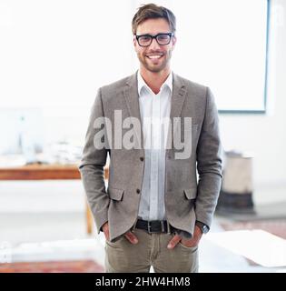 Portare idee nuove all'azienda. Ritratto di un bel giovane uomo d'affari nel suo ufficio. Foto Stock