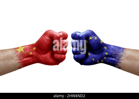 Due mani si pugno l'una all'altra su sfondo bianco. Le bandiere di paese dipinse i pugni, il concetto di crisi di conflitto tra la cina e l'Unione europea Foto Stock