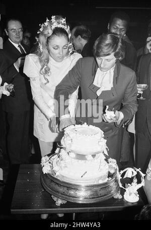 Ricevimento di nozze del regista polacco Roman Polanski e della sua sposa, l'attrice americana Sharon Tate, tenuto presso il London Playboy Club dopo il loro matrimonio presso il Chelsea Register Office. La sposa e lo sposo tagliano la torta alla reception circondato da wishers. 20th gennaio 1968. Foto Stock