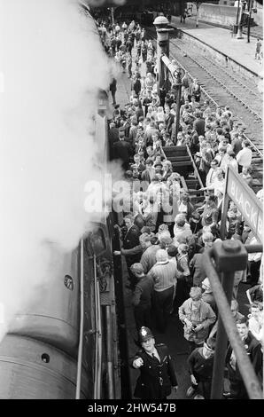 Il 1T57 "quindici Guinea Special", l'ultimo treno passeggeri della linea principale che sarà trasportato con locomotiva a vapore su British Rail il 11th agosto 1968 prima dell'introduzione di un divieto del vapore che è iniziato il giorno successivo. Si trattava di un treno speciale per escursioni in treno organizzato per l'occasione da Liverpool via Manchester a Carlisle e ritorno, ed è stato tirato da quattro diverse locomotive a vapore a turno durante le quattro gambe del viaggio. Foto mostra: Il treno, trainato dalla locomotiva di classe Britannia No. 70013 Oliver Cromwell, è accolto da folle di wellwishers e appassionati come fa una sosta Foto Stock