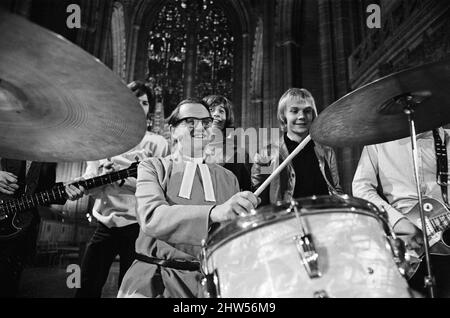 I Bee Gees si esibiscono presso la cattedrale anglicana di Liverpool. I Bee Gees sono i fratelli Maurice, Barry e Robin Gib, Colin Peterson e vince Malouney. Il decano di Liverpool, il Rev. Edward Patey non poteva resistere a provare i tamburi. 14th dicembre 1967. Foto Stock