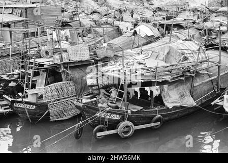 Vita nel 1960s coloniale Hong Kong, con una popolazione in rapida crescita di oltre 4 milioni di persone, molti sono costretti a vivere in baraccopoli e baraccopoli, nella foto di gennaio 1968. I nostri spettacoli di foto ... Sampans, barche cinesi a fondo piatto. Alcuni sampani includono un piccolo rifugio a bordo e possono essere utilizzati come abitazione permanente nelle acque interne. Foto Stock