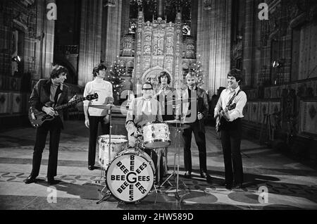 I Bee Gees si esibiscono presso la cattedrale anglicana di Liverpool. I Bee Gees sono i fratelli Maurice, Barry e Robin Gib, Colin Peterson e vince Malouney. Il decano di Liverpool, il Rev. Edward Patey non poteva resistere a provare i tamburi. 14th dicembre 1967. Foto Stock