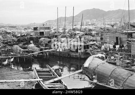 Vita nel 1960s coloniale Hong Kong, con una popolazione in rapida crescita di oltre 4 milioni di persone, molti sono costretti a vivere in baraccopoli e baraccopoli, nella foto di gennaio 1968. I nostri spettacoli di foto ... Sampans, barche cinesi a fondo piatto. Alcuni sampani includono un piccolo rifugio a bordo e possono essere utilizzati come abitazione permanente nelle acque interne. Foto Stock