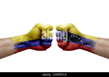 Due mani si pugno l'una all'altra su sfondo bianco. Le bandiere di paese dipinse i pugni, concetto di crisi di conflitto tra colombia e venezuela Foto Stock