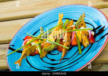 Acciughe in pastella con salsa e verdure Foto Stock