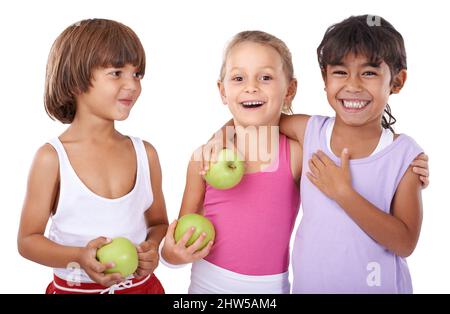 Cresceranno in salute. Tre giovani amici che tengono le mele su uno sfondo bianco. Foto Stock