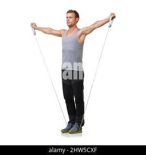 Allungando le braccia. Un giovane uomo in forma che lavora con una banda di resistenza mentre è isolato su uno sfondo bianco. Foto Stock