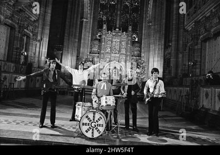 I Bee Gees si esibiscono presso la cattedrale anglicana di Liverpool. I Bee Gees sono i fratelli Maurice, Barry e Robin Gib, Colin Peterson e vince Malouney. Il decano di Liverpool, il Rev. Edward Patey non poteva resistere a provare i tamburi. 14th dicembre 1967. Foto Stock