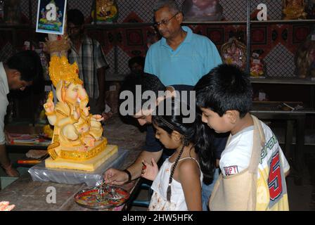Mumbai Maharashtra India Asia 2007 settembre felice famiglia indiana che celebra Ganesh Festival o Chaturthi accoglienza o esecuzione Pooja in laboratorio Foto Stock