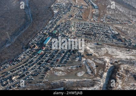 File di auto in piedi al mercato auto girato dall'alto. Vendita di auto usate portate dal Giappone. Foto Stock