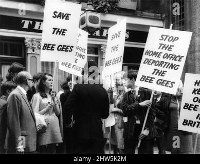 I fan del gruppo pop Bee Gees marciano lungo Carnby-Street, raccogliendo firme per una petizione per protestare contro il rifiuto dell'Home Office di lasciare che i due musicisti australiani del gruppo restino in Gran Bretagna dopo il 17 settembre. I tifosi che trasportano i cartelli hanno anche raccolto un ordine dal poliziotto nella foto. Poi, ha detto loro. Agosto 1967. Foto Stock