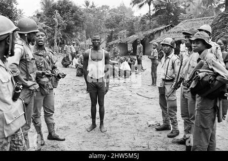 Soldati Biafran qui visti con un soldato nigeriano catturato durante il conflitto Biafran, 11th giugno 1968. La guerra civile nigeriana, nota anche come guerra di Biafran, è durata due anni e mezzo, dal 6 luglio 1967 al 15 gennaio 1970, ed è stata combattuta per contrastare la secessione di Biafra dalla Nigeria. Il popolo indigeno Igbo di Biafra sentì di non poter più coesistere con il governo federale dominato dal nord a seguito dell'indipendenza dalla Gran Bretagna. Le tensioni politiche, economiche, etniche, culturali e religiose si sono infine follate nella guerra civile dopo il colpo di stato militare del 1966, poi contee Foto Stock