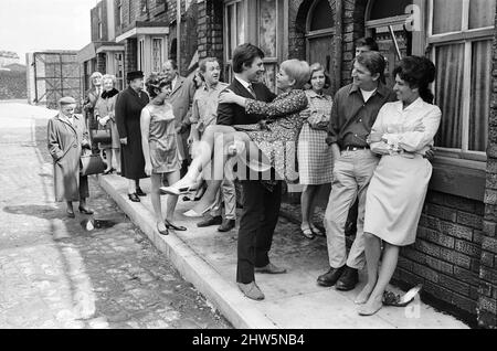 Una nuova strada per 'Coronation Street'. Granada TV hanno costruito un set per l'esterno per riprendere alcune scene. Nella foto sono presenti membri del cast: Il membro del cast Dennis Tanner (Philip Lowrie) con la sua sposa Jenny Sutton (Mitzi Rogers) dopo il matrimonio con Annie Walker (Doris Speed), Ena Sharples (Violet Carson), Emily Nugent (Eileen Derbyshire), Valerie Barlow (Anne Reid), Ken Barlow (William Roache) e Peter Elprensie (Phoenix). 18th maggio 1968. Foto Stock