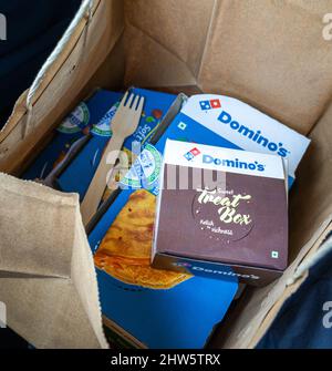 Le scatole di Domino si trovano in una borsa di carta. Ordine di cibo da asporto. Foto Stock