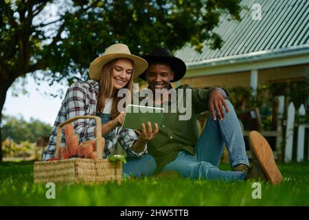 Contadini maschi e femmine seduti in erba verde fresca Foto Stock