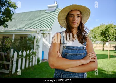 Donna contadina caucasica in piedi all'aperto con le braccia incrociate Foto Stock