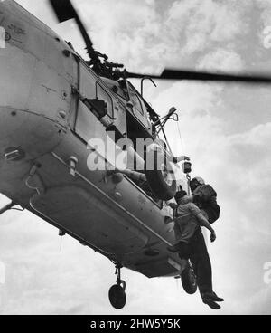 In mani sicure. Un enchman RAF aiuta la parte infortunata a bordo di un elicottero Westland HAR10 Whirlwind mentre si libra sopra le scogliere a Flamborough. 16th agosto 1968 Foto Stock