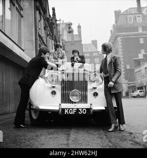 Il Bee Gees esamina un regalo di natale dall'agente Robert Stigwood, un 1948 Rolls Royce Silver Wraith, 12th dicembre 1967. La vettura è stata data come un regalo speciale per segnare & celebrare raggiungendo 1 milioni di vendite record del loro singolo Massachusetts. Quattro dei cinque membri del gruppo guardano l'auto e gli danno un lucido e pulito. Il signor Stigwood aveva la vettura completamente ririvestita e verniciata e il motore è stato revisionato. Nella foto: Colin Peterson, vince Melouney, Barry Gibb e Robin Gibb ad Adams Row, Mayfair (Robin Gibb non disponibile per la foto) Foto Stock