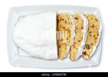 Torta tradizionale di Natale a fette con marzapane e frutta secca isolata su piastra di ceramica Foto Stock