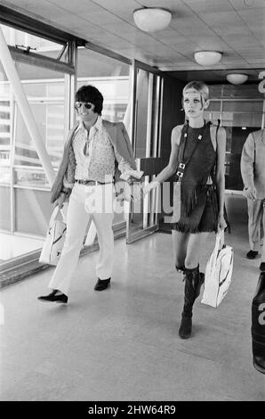 Twiggy, (vero nome Leslie Hornby) modello inglese, visto in un equipaggiamento Hippie lasciando l'aeroporto di Londra Heathrow su TWA per New York, America. Raffigurato con il suo ragazzo e modello Justin de Villeneuve.vedere anche X7903 set di immagini di Twiggy modeling prima dello stesso giorno, nello stesso vestito. Twiggy ha detto del suo vestito Hippie, 'lo amo! Ho un cappello Hippie, è paglia con papaveri sul lato. Ma non ho potuto portarlo oggi perché non va con questo vestito. Quello mostra che non sono un Hippie reale non è? Se fossi, lo indosserei comunque non lo indosserei? ' Continua a dire 'penso che i vestiti c Foto Stock