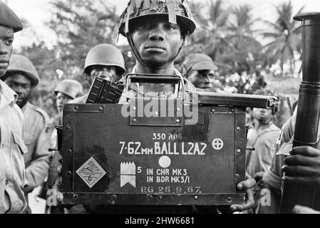 Un soldato Biafran visto qui in possesso di una scatola di esplosivi durante il conflitto Biafran, 11th giugno 1968. La guerra civile nigeriana, nota anche come guerra di Biafran, è durata due anni e mezzo, dal 6 luglio 1967 al 15 gennaio 1970, ed è stata combattuta per contrastare la secessione di Biafra dalla Nigeria. Il popolo indigeno Igbo di Biafra sentì di non poter più coesistere con il governo federale dominato dal nord a seguito dell'indipendenza dalla Gran Bretagna. Le tensioni politiche, economiche, etniche, culturali e religiose si sono infine fomesse nella guerra civile dopo il colpo di stato militare del 1966, poi contro-cou Foto Stock