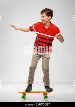 ragazzo sorridente che cavalca su skateboard corto Foto Stock