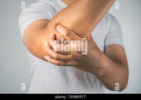 L'uomo è un gomito di dolore. Questi sintomi possono causare da sport, duro lavoro con il braccio. Primo piano. Foto Stock