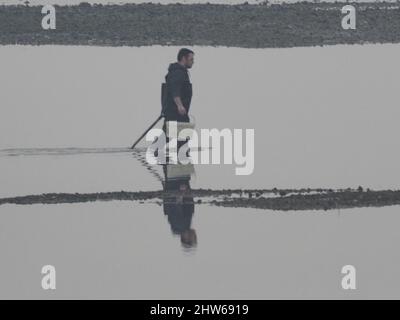 Sheerness, Kent, Regno Unito. 4th Mar 2022. UK Meteo: Una mattina nebbia e marea ultra bassa a Sheerness, Kent. Un scavatore di esca alla bassa marea. Credit: James Bell/Alamy Live News Foto Stock