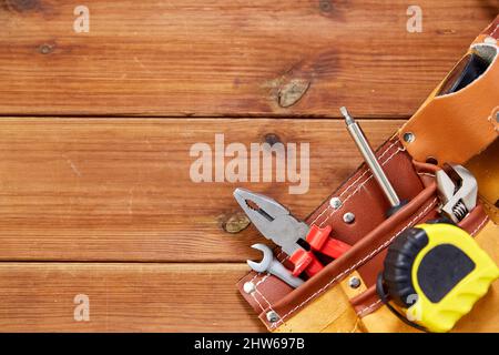 diversi attrezzi di lavoro nel nastro su tavole di legno Foto Stock