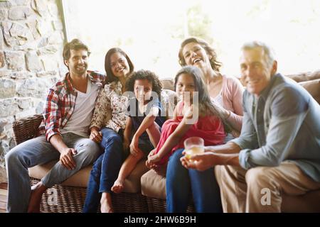 Tre generazioni di risate e di amore. Un ritratto di una famiglia di tre generazioni che si rilassa a casa. Foto Stock