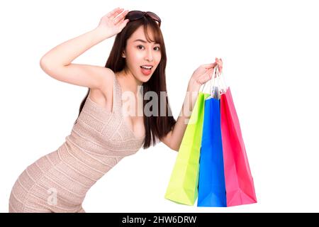 Felice giovane donna in occhiali da sole e in possesso di borse shopping Foto Stock