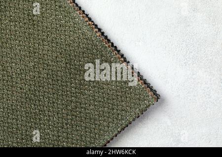 sfondo testurizzato o carta da parati da tessuto ruvido di colore verde calce e uno spazio vuoto. Foto Stock