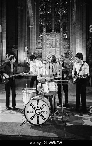 I Bee Gees si esibiscono presso la cattedrale anglicana di Liverpool. I Bee Gees sono i fratelli Maurice, Barry e Robin Gib, Colin Peterson e vince Malouney. Il decano di Liverpool, il Rev. Edward Patey non poteva resistere a provare i tamburi. 14th dicembre 1967. Foto Stock