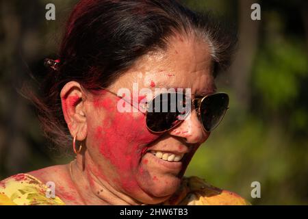 Ritratto di felice indiano in pensione Donna godendo con polvere di colore Holi erbe chiamato Gulal o Abir Rang Aber durante Dol Purnima. Invecchiato bello Foto Stock