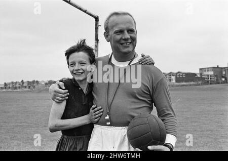 David Bradley, (14 anni) che suona la parte di Billy Casper, raffigurata con il suo Kestral, sul set cinematografico del film Kes. Qui Billy Casper sta giocando il portiere nella scena della partita di calcio della scuola. Con lui c'è il signor Sugden, interpretato da Brian Glover. Sugden pensa di essere Bobby Charlton, che indossa una maglietta del Manchester United e ordina i suoi giocatori sul campo. KES è un film drammatico del 1969 diretto da Ken Loach e prodotto da Tony Garnet. Il film è basato sul romanzo del 1968 A Kestrel for a Knave, scritto dall'autore Barry Hines, nato da Barnsley. Il film è classificato settimo nel Briti Foto Stock