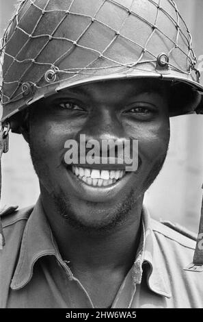 Un soldato di Biafran sorridente visto qui durante il concico di Biafran. 11th giugno 1968 la guerra civile nigeriana, nota anche come guerra di Biafran, durò due anni e mezzo, dal 6 luglio 1967 al 15 gennaio 1970, e fu combattuta per contrastare la secessione di Biafra dalla Nigeria. Il popolo indigeno Igbo di Biafra sentì di non poter più coesistere con il governo federale dominato dal nord a seguito dell'indipendenza dalla Gran Bretagna. Le tensioni politiche, economiche, etniche, culturali e religiose si sono infine trasformate in una guerra civile dopo il colpo di stato militare del 1966, poi contro-colpo di stato, che ha portato al colpo di stato Foto Stock