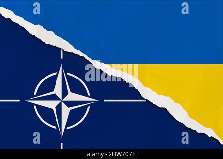 Ucraina e la bandiera della NATO hanno strappato la carta grunge sfondo. Astratto conflitto politico Ucraina e NATO, concetto di guerra trama sfondo Foto Stock