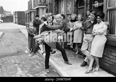 Una nuova strada per 'Coronation Street'. Granada TV hanno costruito un set per l'esterno per riprendere alcune scene. Nella foto sono presenti membri del cast: Il membro del cast Dennis Tanner (Philip Lowrie) con la sua sposa Jenny Sutton (Mitzi Rogers) dopo il matrimonio con Annie Walker (Doris Speed), Ena Sharples (Violet Carson), Emily Nugent (Eileen Derbyshire), Valerie Barlow (Anne Reid), Ken Barlow (William Roache) e Peter Elprensie (Phoenix). 18th maggio 1968. Foto Stock