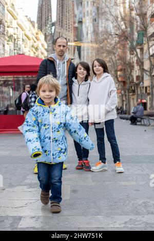 Carino bambini turisti ammirando Barcellona città, famiglia viaggi con i bambini in Spagna. Famiglia di fronte alla Sagrada Familia Foto Stock