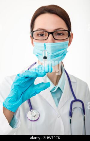 Un infermiere tiene una siringa prima di effettuare l'iniezione. Il concetto di vaccinazione. Foto Stock