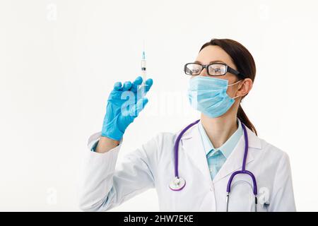 Un infermiere tiene una siringa prima di effettuare l'iniezione. Il concetto di vaccinazione. Foto Stock