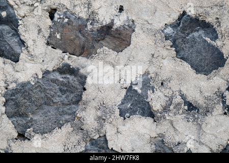 La texture di un muro di pietra. Il castello vecchio muro di pietra la texture dello sfondo. Muro di pietra come sfondo o texture. Parte di un muro di pietra, per sfondo o del testo Foto Stock