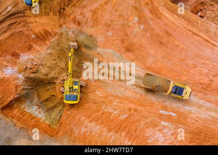 Escavatore durante il movimento terra in buca aperta su attrezzature pesanti per il movimento terra di costruzione per il carico di scavo Foto Stock