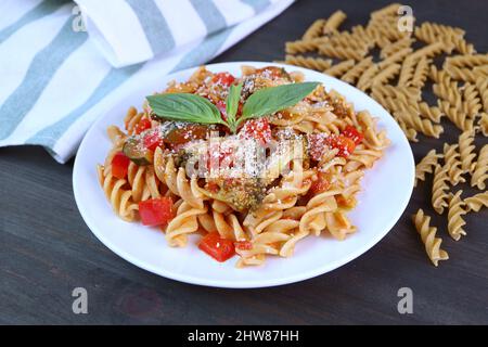 Piatto di pasta di Fusilli fresca cotta gustosa e sana in salsa di pomodoro sul tavolo da cucina Foto Stock