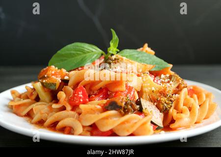 Primo piano di deliziosa pasta di Fusilli integrale in salsa di pomodoro servita su sfondo nero Foto Stock