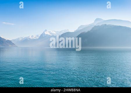 Paesaggio di montagna. I raggi del sole disegnano ombre sulle acque del Lago di Lucerna. Foto Stock