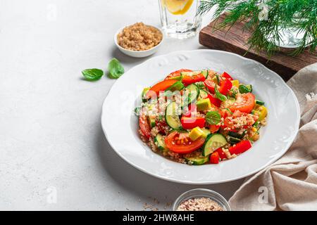 Insalata di tovouleh, insalata vegetariana di Levantine con bulgur, quinoa, pomodoro, cetriolo. Vista laterale, spazio di copia. Foto Stock
