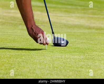 Questo sta per andare avanti. Scatto ritagliato di un golfer che mette una sfera su un tee. Foto Stock